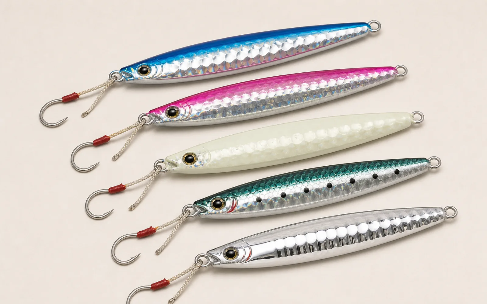 Heavy butterfly-style metal jigs in blue, pink, silver, and glow colors with assist hooks